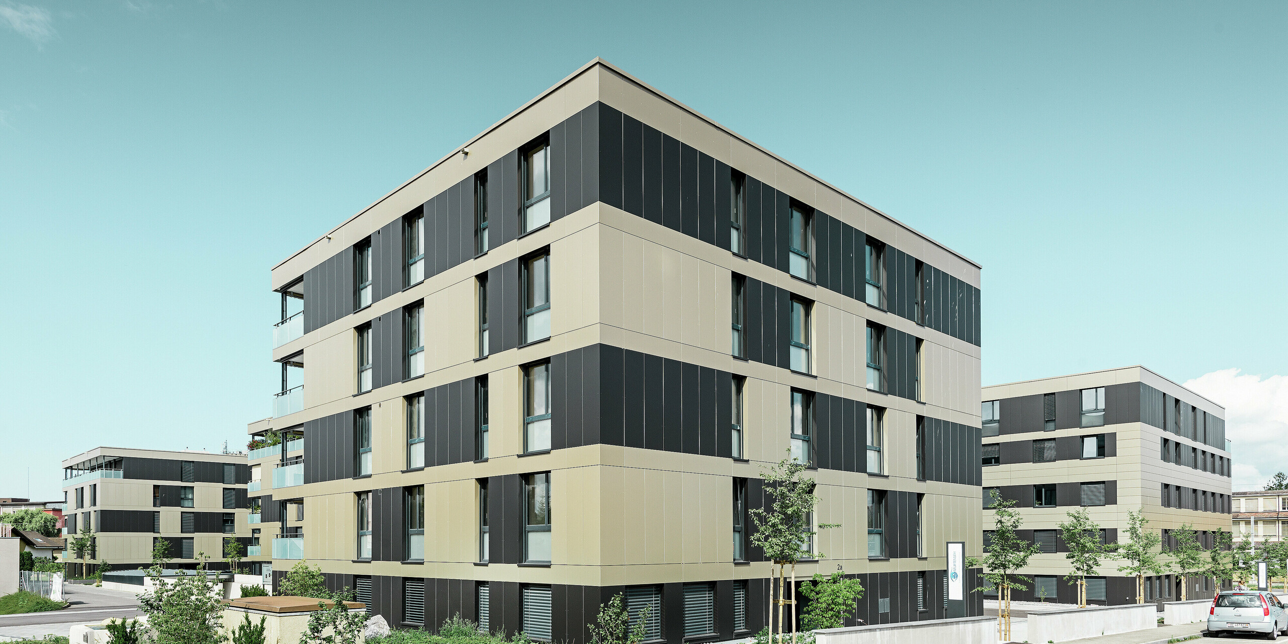Kubusvormig woongebouw met aluminiumgevel in brons en zwartgrijze elementen