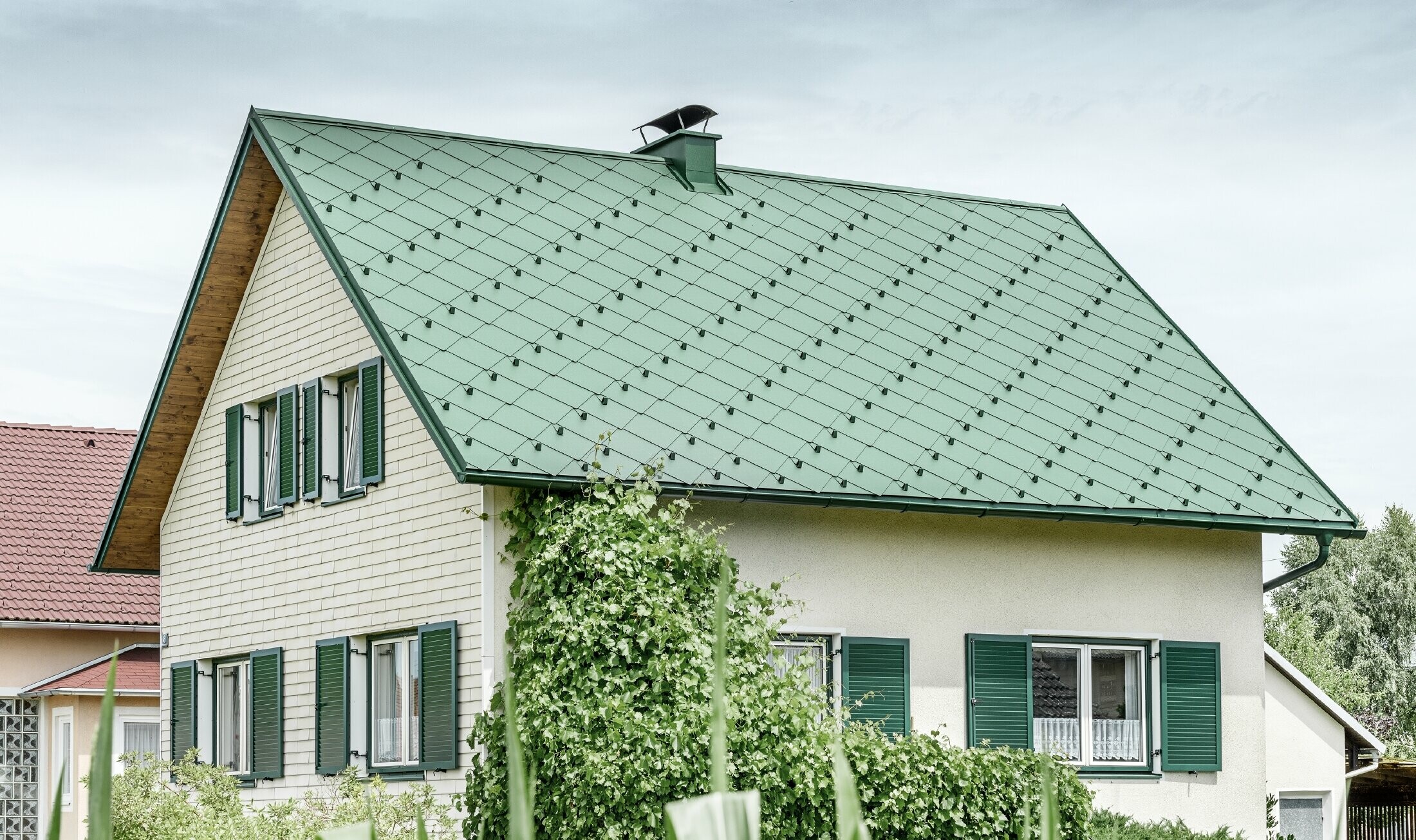 Klassieke eengezinswoning met zadeldak met een dakbedekking van aluminium in mosgroen met groene luiken