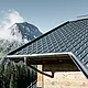 PREFA-dakpan in een bergstreek - dakplaat in antraciet, gemonteerd op de berghut in Lech am Arlberg met bergen op de achtergrond; PREFA-dakgoot in antraciet; houten gevel