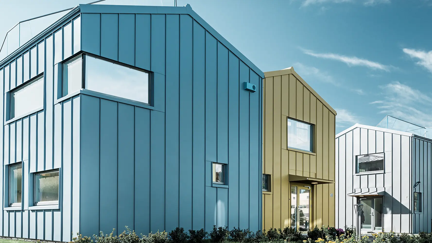 Eengezinswoningen in een wooncomplex met kleurrijke daken en aluminium gevels