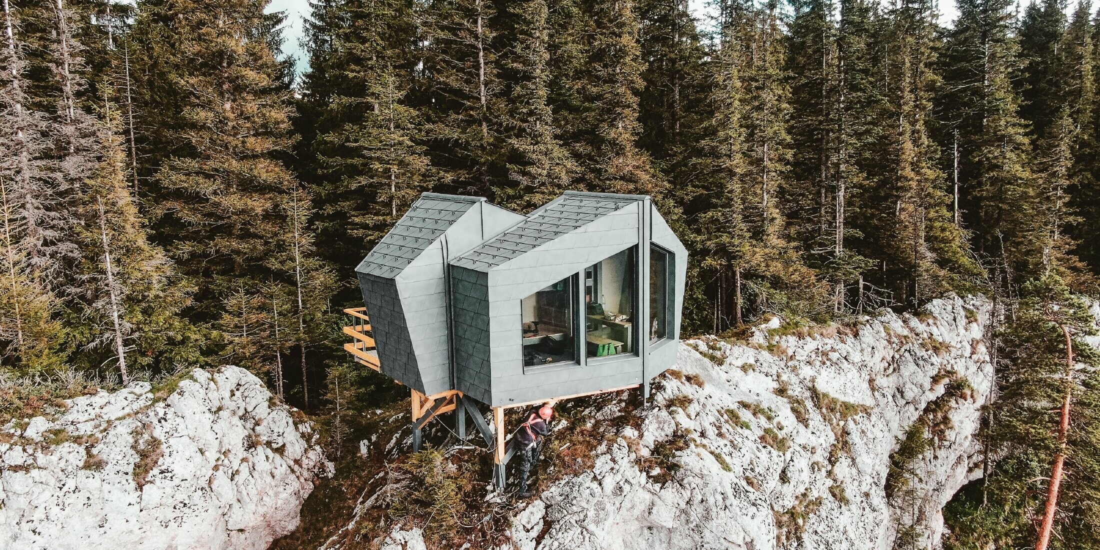 Besondere Schutzhütte, Biwak, in exponierter Lage über Felsen mit großen Fenstern ist komplett mit der PREFA Dachschindel DS.19 in P.10 Steingrau eingedeckt.