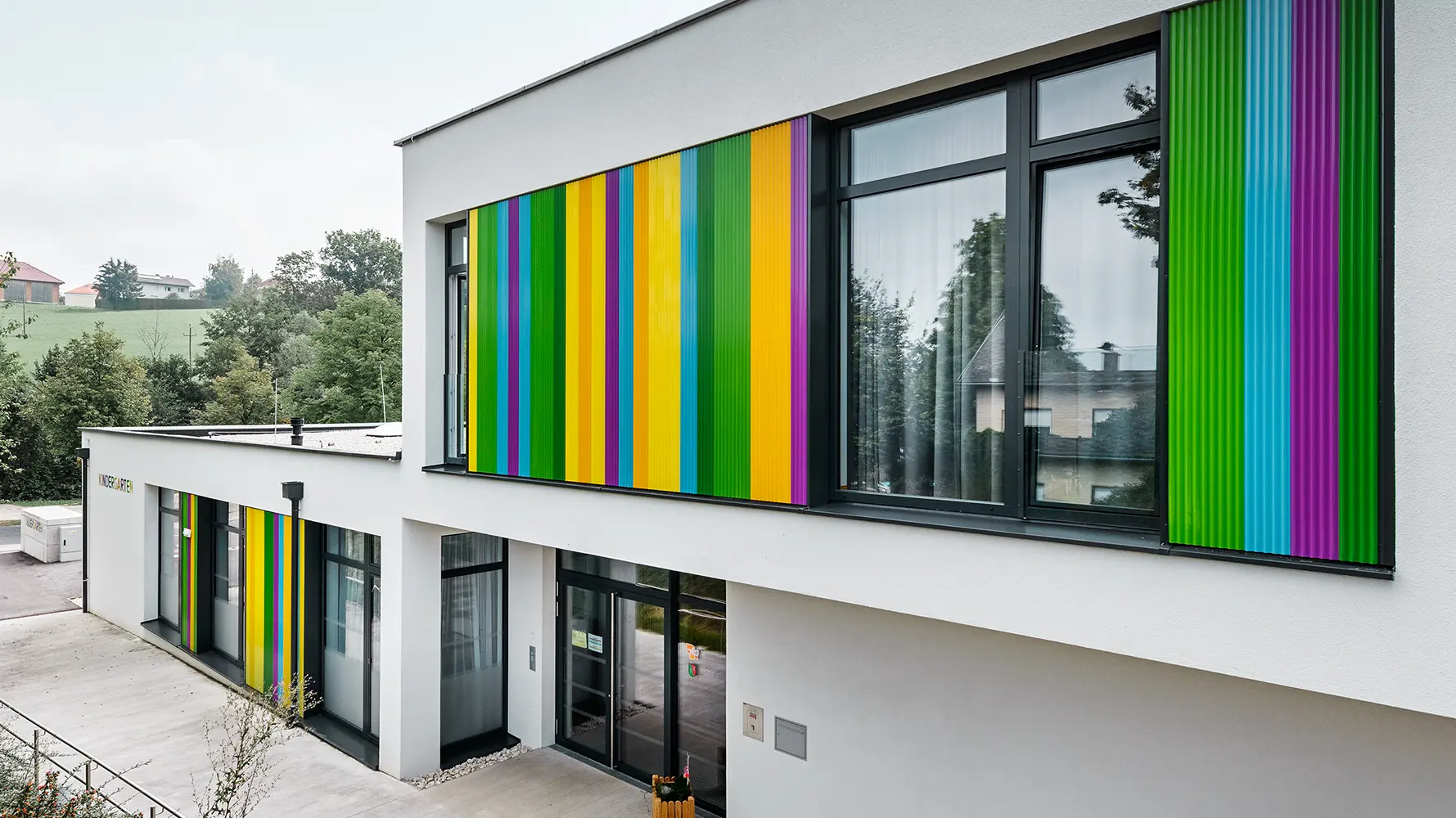 Kleuterschool met kleurrijk PREFA-kartelprofiel in combinatie met een gepleisterde gevel