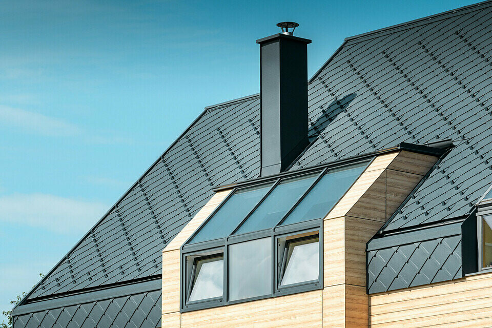 Eengezinswoning met zadeldak zonder uitstekend dak met een gevel in houtlook en een aluminium dak in antraciet