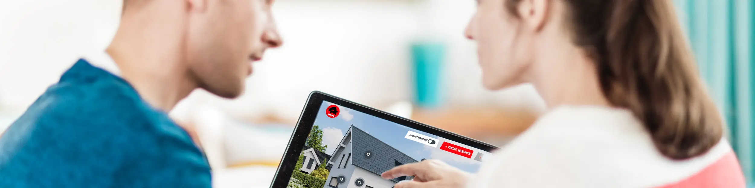 Een koppel zit samen aan tafel en kijkt op een tablet naar de digitale voorstelling van een huis met dak, gevel en zonnepanelen uit aluminium – in de context van de PREFA-gids voor dak, gevel en zonnepanelen bij nieuwbouw en renovatie.