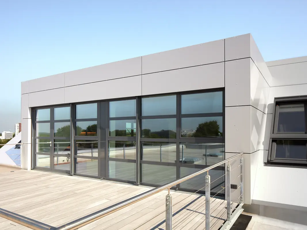 Auf dem Bild sieht man die Dachterrasse und große Glasfront des einsteineins in Kiel, das mit PREFABOND Aluminium Verbundplatten erneuert wurde.