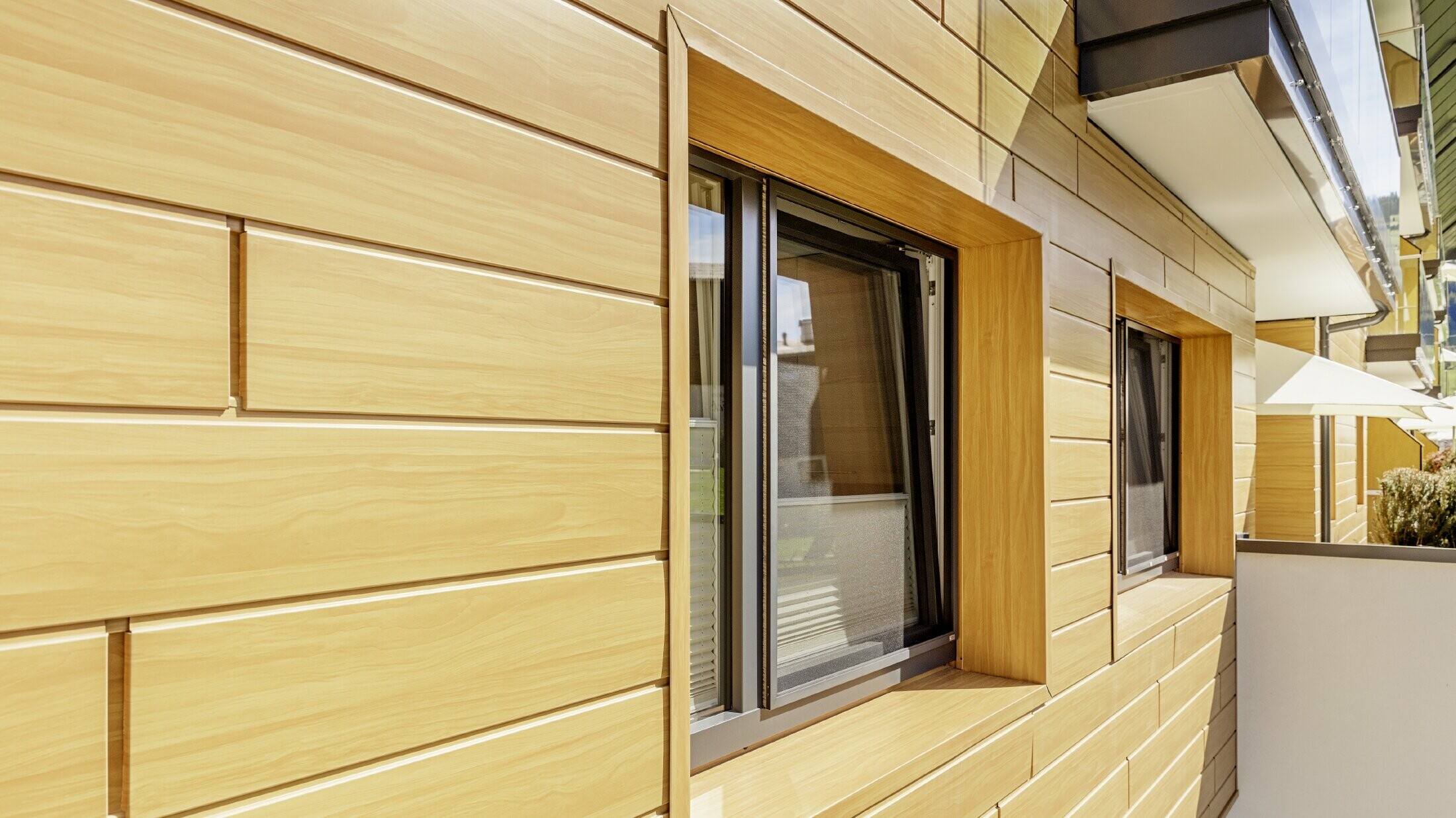 Gedetailleerde opname van een raamomlijsting met de PREFA sidings in houtoptiek bij de herenboerderij Lutz in Schattwald.