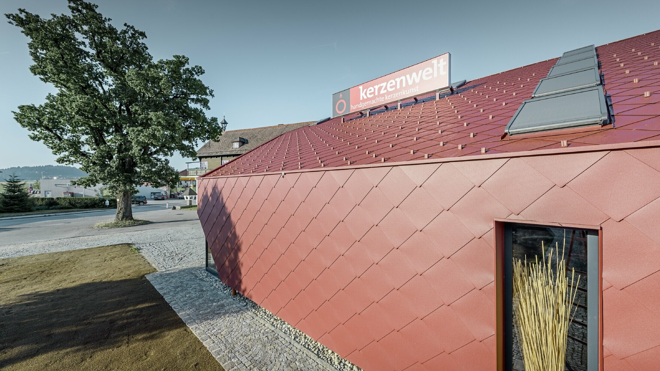 De Kerzenwelt in Schlägl is rondom opnieuw gedekt met de PREFA losange. De dakbedekking en de gevelbekleding zijn uitgevoerd met de losange 44 × 44 in oxiderood.