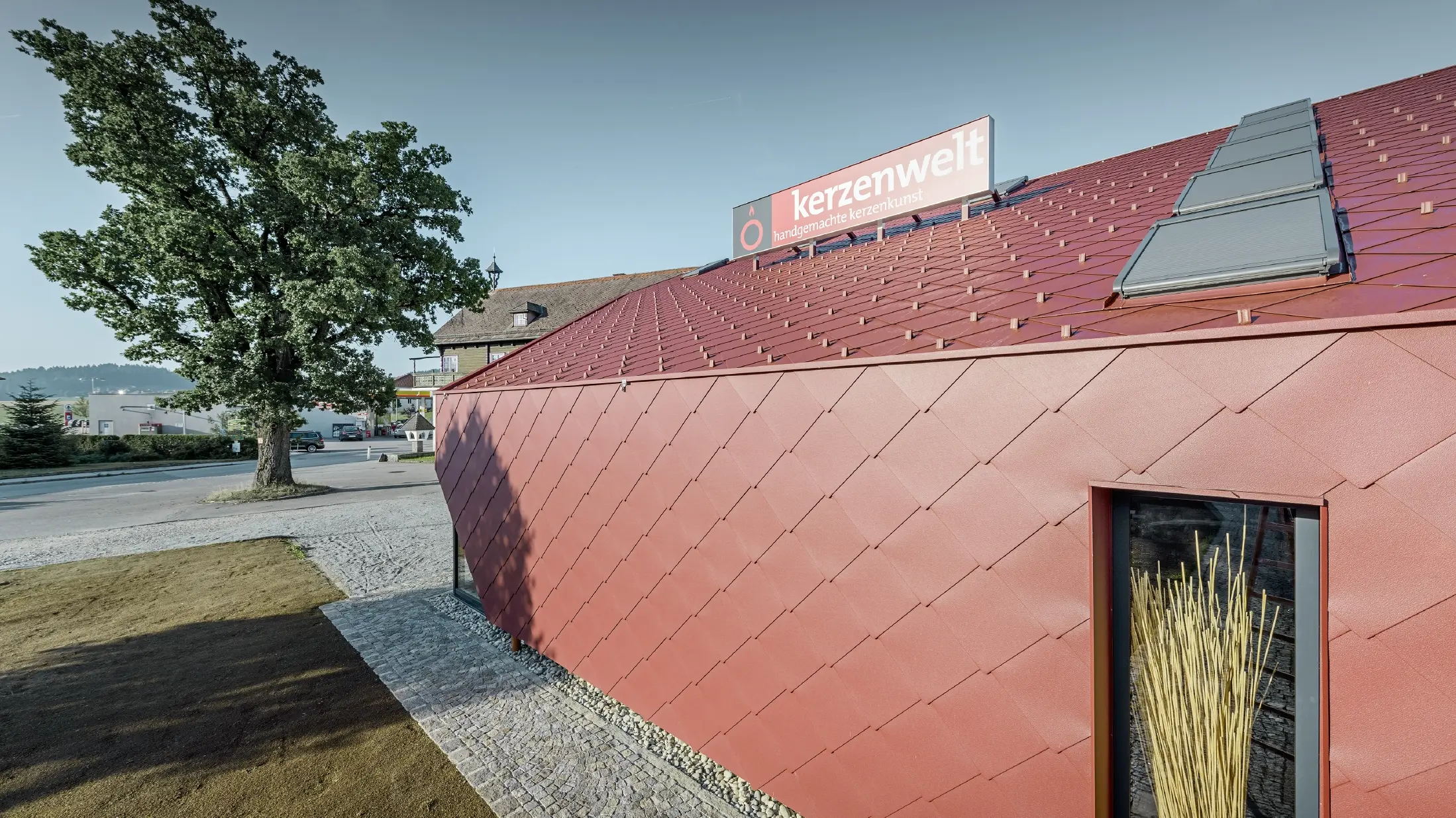 De Kerzenwelt in Schlägl is rondom opnieuw gedekt met de PREFA losange. De dakbedekking en de gevelbekleding zijn uitgevoerd met de losange 44 × 44 in oxiderood.