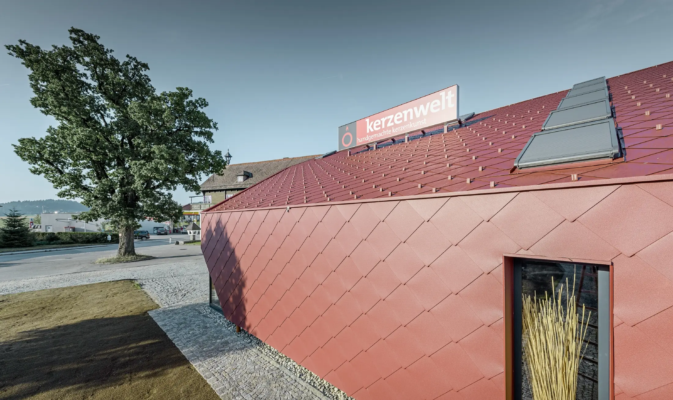 De Kerzenwelt in Schlägl is rondom opnieuw gedekt met de PREFA losange. De dakbedekking en de gevelbekleding zijn uitgevoerd met de losange 44 × 44 in oxiderood.
