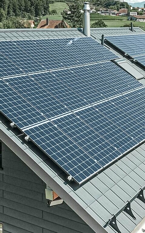 [Translate to Dutch:] PREFA Dachplatte in der Farbe anthrazit mit einer montierten Photovoltaik-Anlage als Aufdach-Lösung.