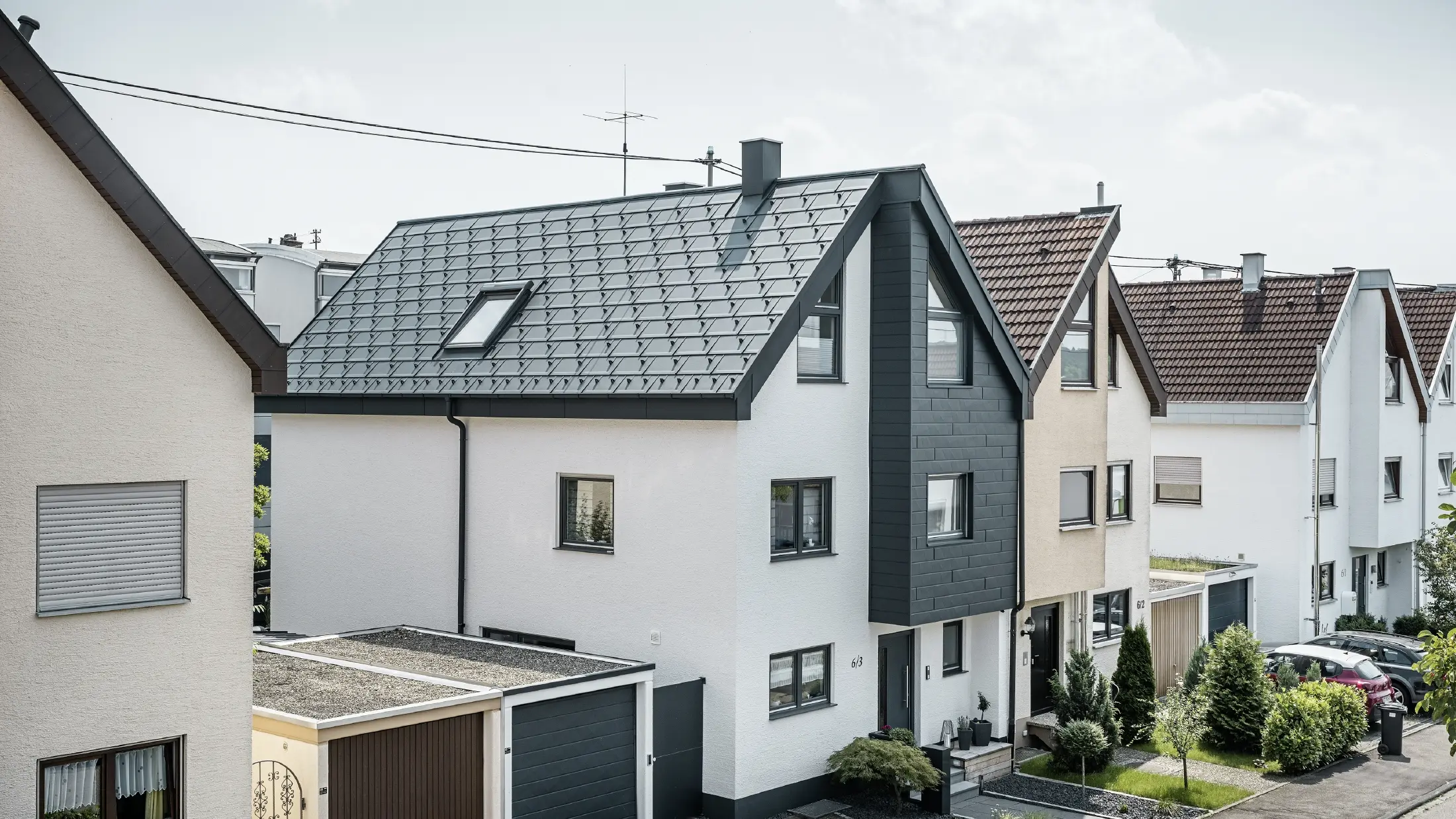De helft van een twee-onder-een-kapwoning werd al gerenoveerd, met een frisse witte pleistergevel gecombineerd met een PREFA Siding.X gevel in antraciet. Het dak werd bedekt met de PREFA dakpan R.16. Het dakafvoersysteem bestaat uit de vierkante bakgoot inclusief PREFA afvoerbuis.