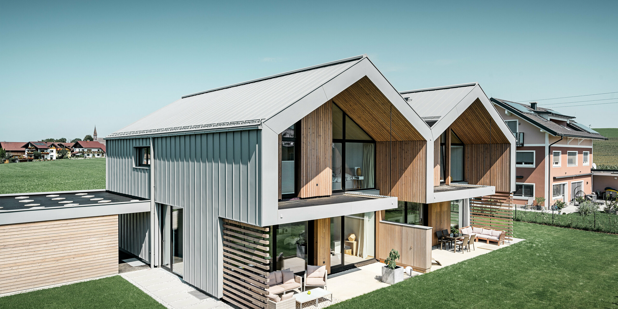 Moderne dubbele huizen met PREFALZ bouwschil, dak en gevel zijn bekleed met PREFALZ in patinagrijs, met vierkante buis