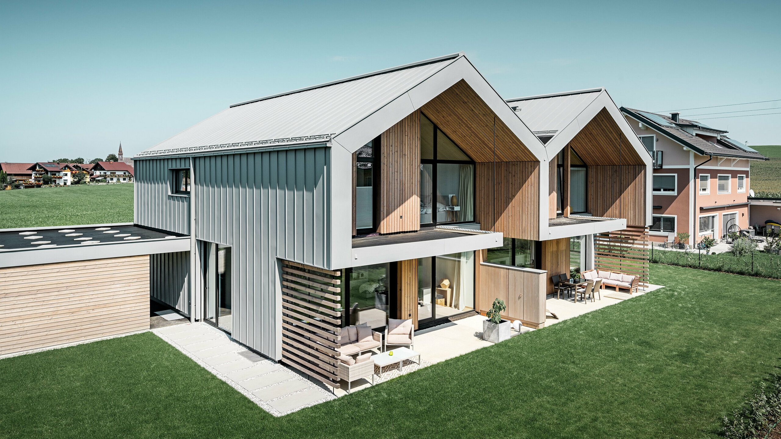 Moderne dubbele huizen met PREFALZ bouwschil, dak en gevel zijn bekleed met PREFALZ in patinagrijs, met vierkante buis