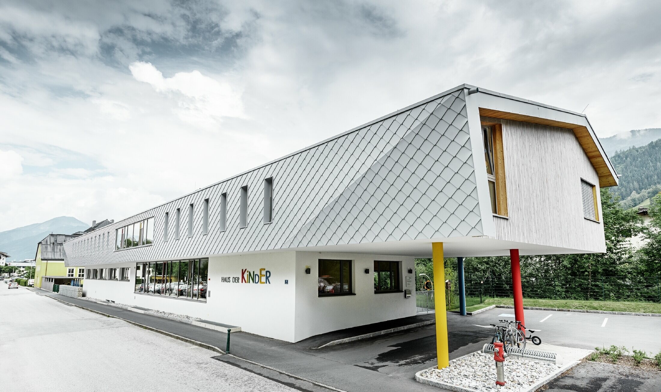 Nieuwe kleuterschool in Kaprun (Oostenrijk) met moderne aluminiumgevel bedekt met PREFA-gevellosanges in prefawit